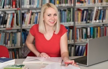 Eine Doktorandin in der Bibliothek beim Schreiben der Doktorarbeit