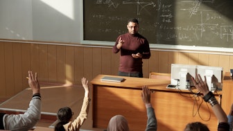 Ein junger Professor in einem Hörsaal vor Studierenden