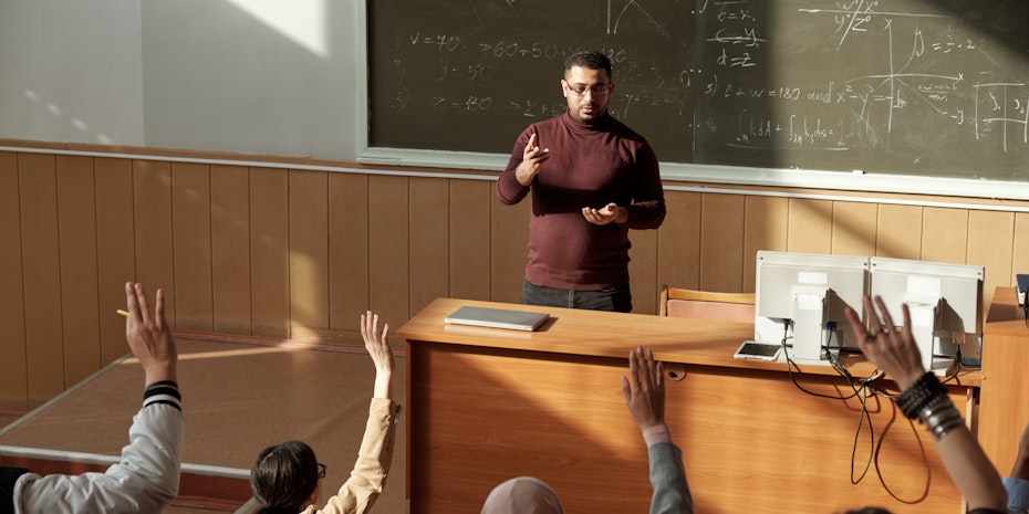 Ein junger Professor in einem Hörsaal vor Studierenden