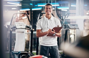 Ein Mann mit Klemmbrett in einem Fitnessraum