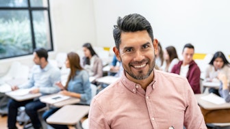 Ein lächelnder Juniorprofessor mit Studenten
