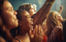 Singende und jubelnde Menschen bei einem Musikfestival