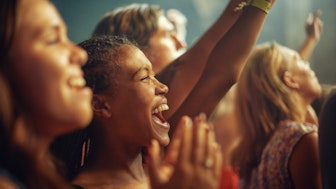 Singende und jubelnde Menschen bei einem Musikfestival