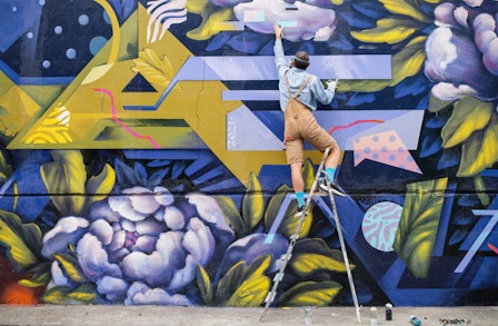 Kunst im öffentlichen Raum: Ein Künstler bemalt eine Wand