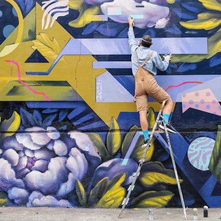 Kunst im öffentlichen Raum: Ein Künstler bemalt eine Wand
