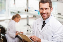 Ein lachender Laborleiter mit Klemmbrett