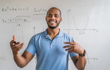 Ein Mathematiker vor einem Whiteboard mit Graphen und Berechnungen