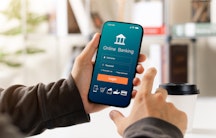 Ein Postdoc prüft am Handy per Online-Banking sein Gehalt