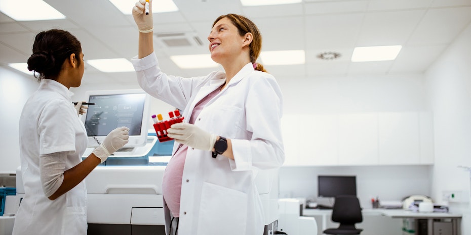 Eine schwangere Doktorandin begutachtet eine Probe 