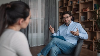 Ein Mann im Gespräch mit einer Psychologin oder Psychotherapeutin