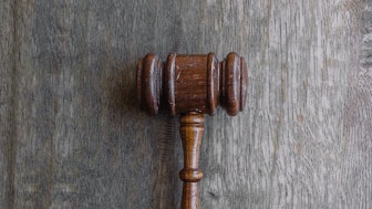 Richterhammer vor grauem Hintergrund für Rechtsprechung bei einer Konkurrentenklage