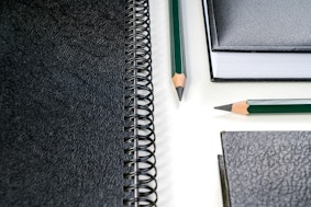 Stifte und Notizheft als Symbolbild für Bewerbung Promotion Doktorand Doktorarbeit