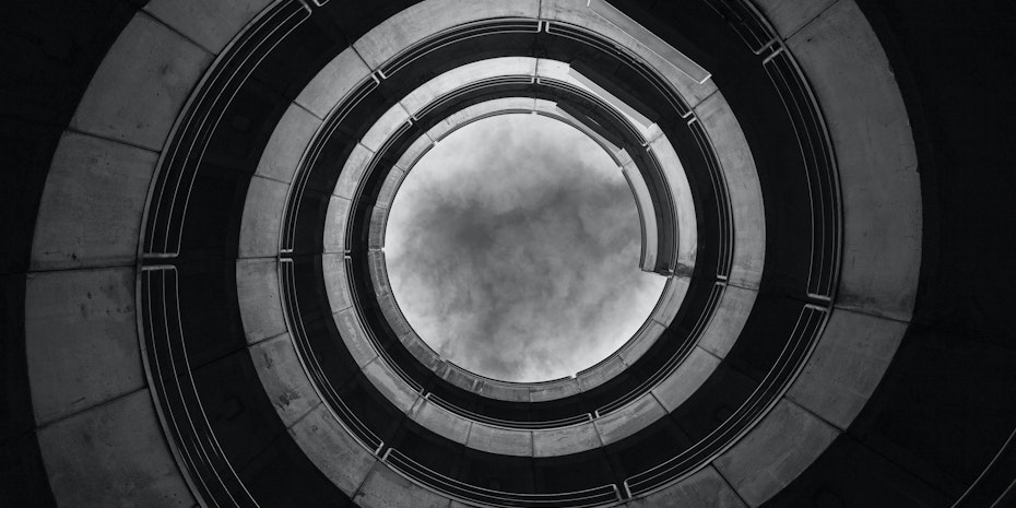 Dunkles spiralförmiges Treppenhaus als Symbolbild für ein Burnout-Syndrom