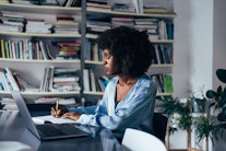 Eine afrodeutsche Wissenschaftsmanagerin arbeitet am Schreibtisch